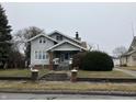 Two-story home with brick accents, covered front porch, and a neatly landscaped yard at 2025 Main St, Elwood, IN 46036