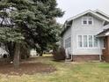 Side view of a well-maintained two-story home with a tree-lined yard at 2025 Main St, Elwood, IN 46036