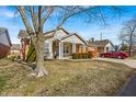 Cozy one-story home with a covered entry, attached garage, and a mature tree in the yard at 2215 Elm Leaf Ln, Indianapolis, IN 46229