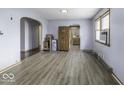 Spacious living room with modern laminate flooring, neutral paint, and ample natural light from the windows at 3807 S Olney St, Indianapolis, IN 46237