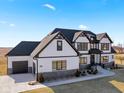 Beautiful exterior view of this Tudor-style home and attached two car garage, accented by stone details and meticulous landscaping at 3966 Chapel Hl Ct, Bargersville, IN 46106