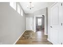Bright entryway with light gray walls, wood floors, and a view into an adjacent room at 5461 Oak Knoll Dr, Whitestown, IN 46075