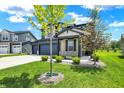 Attractive two-story home with three car garage, lush green lawn and young trees under a bright sunny sky at 5461 Oak Knoll Dr, Whitestown, IN 46075
