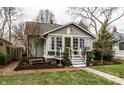 Quaint home with beautiful landscaping, cozy front porch, and a bright green front door at 5626 Winthrop Ave, Indianapolis, IN 46220