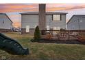 A backyard with a deck, a brick chimney, and a green slide at 6546 W Dickens Xing, McCordsville, IN 46055