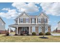 Beautiful two-story home with covered front porch, lovely landscaping, and inviting curb appeal at 6546 W Dickens Xing, McCordsville, IN 46055