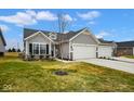 Charming single-story home with gray siding, a two-car garage, and a well-manicured front yard at 7091 Lillian Pl, Cumberland, IN 46229