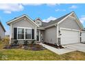 Charming single-story home with gray siding, a two-car garage, and a well-manicured front yard at 7091 Lillian Pl, Cumberland, IN 46229