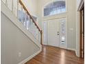 Inviting foyer with hardwood floors, staircase, and transom window above the front door at 7238 River Birch Ln, Indianapolis, IN 46236