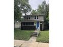 Charming two-story home featuring a blue front door and a brick foundation at 749 W 32Nd St, Indianapolis, IN 46208