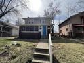 Classic two-story home with a bright blue door, complemented by a brick-and-siding exterior and a cozy screened porch at 749 W 32Nd St, Indianapolis, IN 46208
