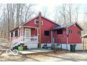 Quaint red home featuring a cozy front porch and a small back deck with a peaceful wooded backdrop at 9464 N State Rd 135, Morgantown, IN 46160