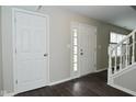 Bright entryway showcasing a white front door with glass panels, hardwood floors, and white trim at 9685 Glowing Flame Dr, Fishers, IN 46037