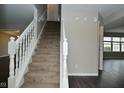 Inviting entryway featuring a carpeted staircase with white railing, complemented by neutral walls and dark hardwood flooring at 9685 Glowing Flame Dr, Fishers, IN 46037