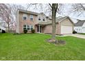 Charming two-story home with brick and vinyl facade, complemented by a well-maintained lawn and mature trees in the front yard at 9685 Glowing Flame Dr, Fishers, IN 46037