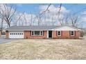 Charming brick ranch-style home with an attached garage and a well-maintained front yard at 1313 Oakwood Trl, Indianapolis, IN 46260