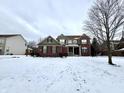 Charming two-story brick home featuring a classic design and snow covered front yard at 14596 Toponas Pl, Fishers, IN 46040