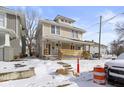 Two-story home featuring a spacious front porch, classic design, and snow-covered yard at 17 Parkview Ave, Indianapolis, IN 46201