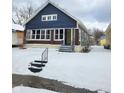 A cozy blue bungalow with brick accents and a snow-covered front yard at 2309 N Dearborn St, Indianapolis, IN 46218
