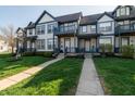 Well-maintained townhome featuring blue trim, lush lawn, and welcoming entryway at 2357 Central Ave, Indianapolis, IN 46205