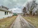 View of long driveway leading to a shed, firepit, and additional parking at 3049 Foltz St, Indianapolis, IN 46241