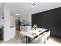 Dining area with a modern light fixture, table for six, adjacent to a stylish kitchen with stainless steel appliances at 335 E St Clair St, Indianapolis, IN 46202