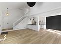 Spacious living room with white walls, hardwood floors, staircase, and an open layout to the kitchen area at 335 E St Clair St, Indianapolis, IN 46202