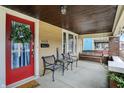 Inviting covered porch featuring outdoor seating, string lights, and a vibrant red front door at 4029 Broadway St, Indianapolis, IN 46205