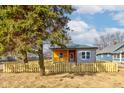 View of the charming single-story home with picket fence, siding and a cute front porch beneath a cloudy sky at 4804 Brouse Ave, Indianapolis, IN 46205