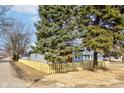 View of charming home with siding and a cute front porch screened by mature landscaping and a picket fence at 4804 Brouse Ave, Indianapolis, IN 46205