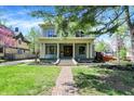 Inviting two-story home features a classic front porch and lush, landscaped front yard at 828 Woodruff Place Middle Dr, Indianapolis, IN 46201