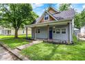 Charming home featuring a cozy front porch, blue door, and a well-maintained lawn at 952 N Concord St, Indianapolis, IN 46222