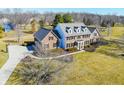 Expansive aerial view of the brick home with a curved driveway and large, lush green lawn at 10120 Fox Trce, Zionsville, IN 46077