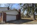 Spacious two-car garage with an attached brick chimney and driveway at 11506 Rolling Springs Dr, Carmel, IN 46033