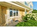 Charming front porch featuring rocking chairs, stone accents, and lush hydrangeas at 13060 Wembly Cir, Carmel, IN 46033