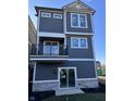 Stylish three-story home with gray siding, white trim, and a balcony, designed for modern living at 15407 Mystic Rock Dr, Carmel, IN 46033