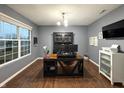 Home office with hardwood floors, ample lighting, and modern desk setup at 1566 Dorset Dr, Avon, IN 46123