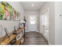 Inviting foyer with wood floors, a decorative console table, beautiful art, and a front door featuring decorative glass at 16052 Sedalia Dr, Fishers, IN 46040