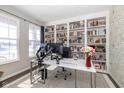Bright home office with custom built-in bookshelves, a large window, and a neutral color palette perfect for productivity at 16052 Sedalia Dr, Fishers, IN 46040