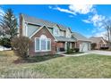 Two-story home featuring brick accents, a well-maintained lawn, and mature trees at 1852 Lakeside Ln, Indianapolis, IN 46229