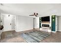 The spacious living room features a modern fireplace, ceiling fan and stylish decor at 19215 Calico Aster Dr, Noblesville, IN 46062