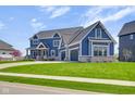Charming blue two-story home with three-car garage and well-manicured lawn at 20451 Chatham Hills Blvd, Westfield, IN 46074