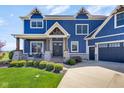 Inviting front porch with seating area and stone accents on a beautiful blue home at 20451 Chatham Hills Blvd, Westfield, IN 46074