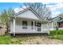 Charming single-story home with a covered front porch, white siding, and a well-maintained yard at 2137 Napoleon St, Indianapolis, IN 46203