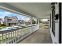 Inviting front porch with white railings, offering a glimpse of the neighborhood street and charming homes at 2137 Napoleon St, Indianapolis, IN 46203