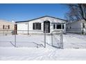 Charming single-story home featuring white siding, black accents, and a chain-link fence at 2306 Finley Ave, Indianapolis, IN 46203