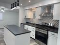Modern kitchen features new stainless steel appliances and black and white backsplash at 2306 Finley Ave, Indianapolis, IN 46203