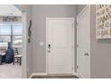 Bright entryway featuring a white front door, wood-look floors, and modern decor at 293 Carrick Glen Blvd, Pendleton, IN 46064