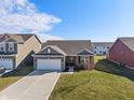 Attractive one-story home featuring a brick facade, well-kept lawn, and an attached two-car garage in a residential area at 293 Carrick Glen Blvd, Pendleton, IN 46064