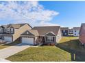 Attractive one-story home featuring a brick facade, well-kept lawn, and an attached two-car garage in a residential area at 293 Carrick Glen Blvd, Pendleton, IN 46064